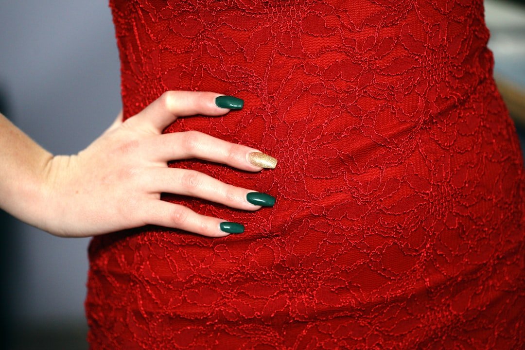 Hands with glossy classic red nail polish on neatly shaped nails