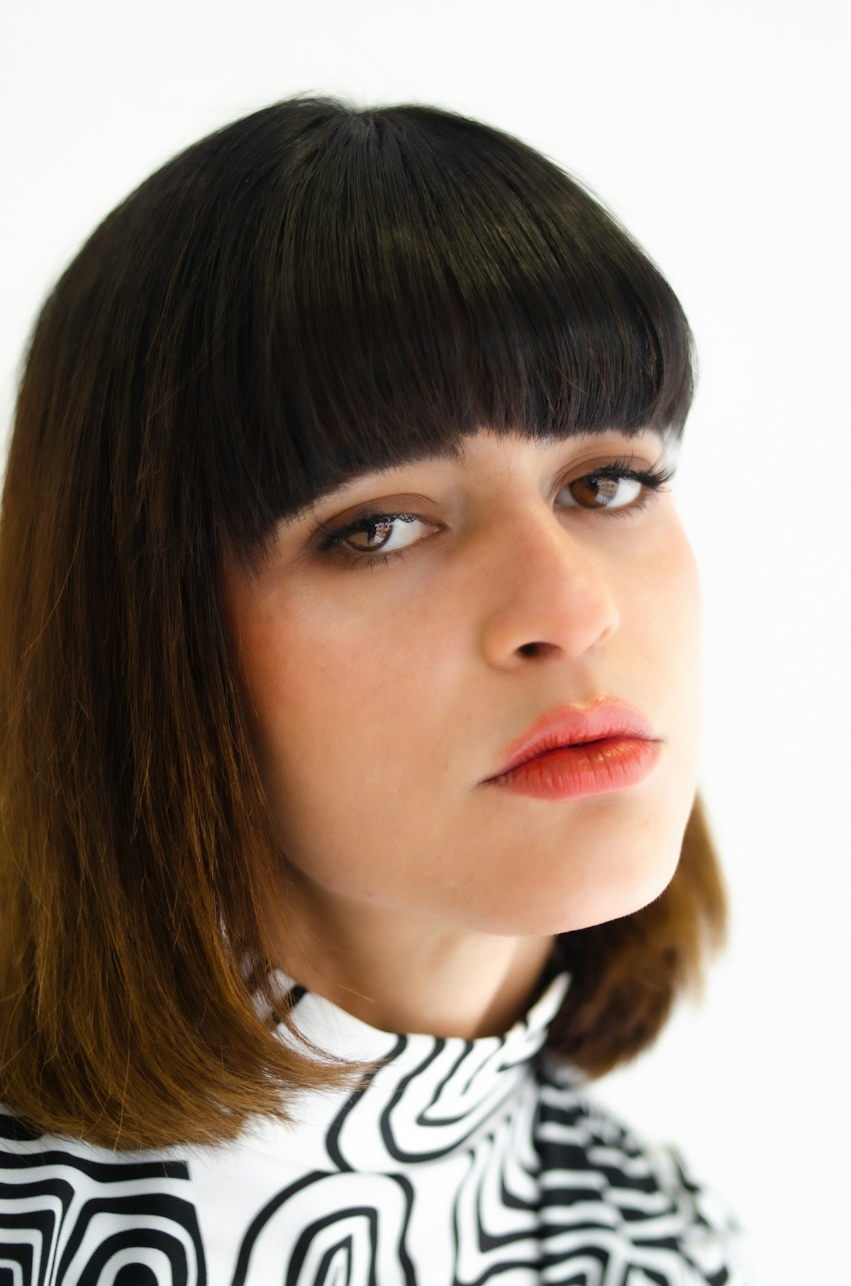 Woman with a dark bob haircut and bangs showing a strong short silhouette