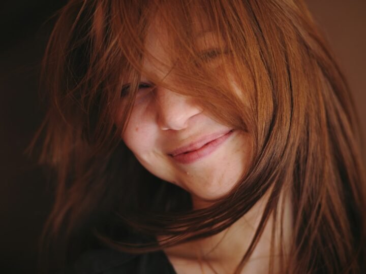 Smiling woman with dark glossy hair and visible natural depth