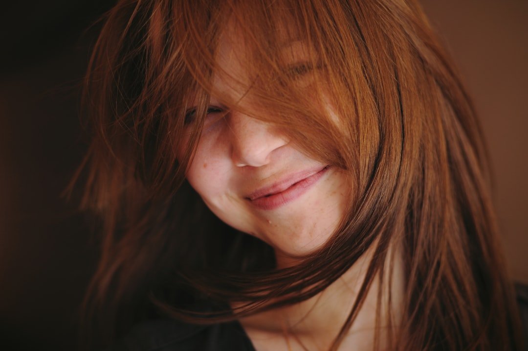 Smiling woman with dark glossy hair and visible natural depth
