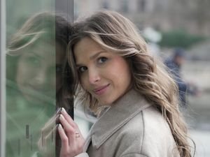 Woman with brown hair and lighter face-framing highlights