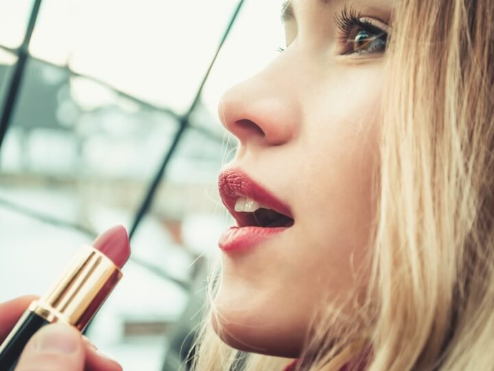 Woman holding lipstick in a close beauty portrait