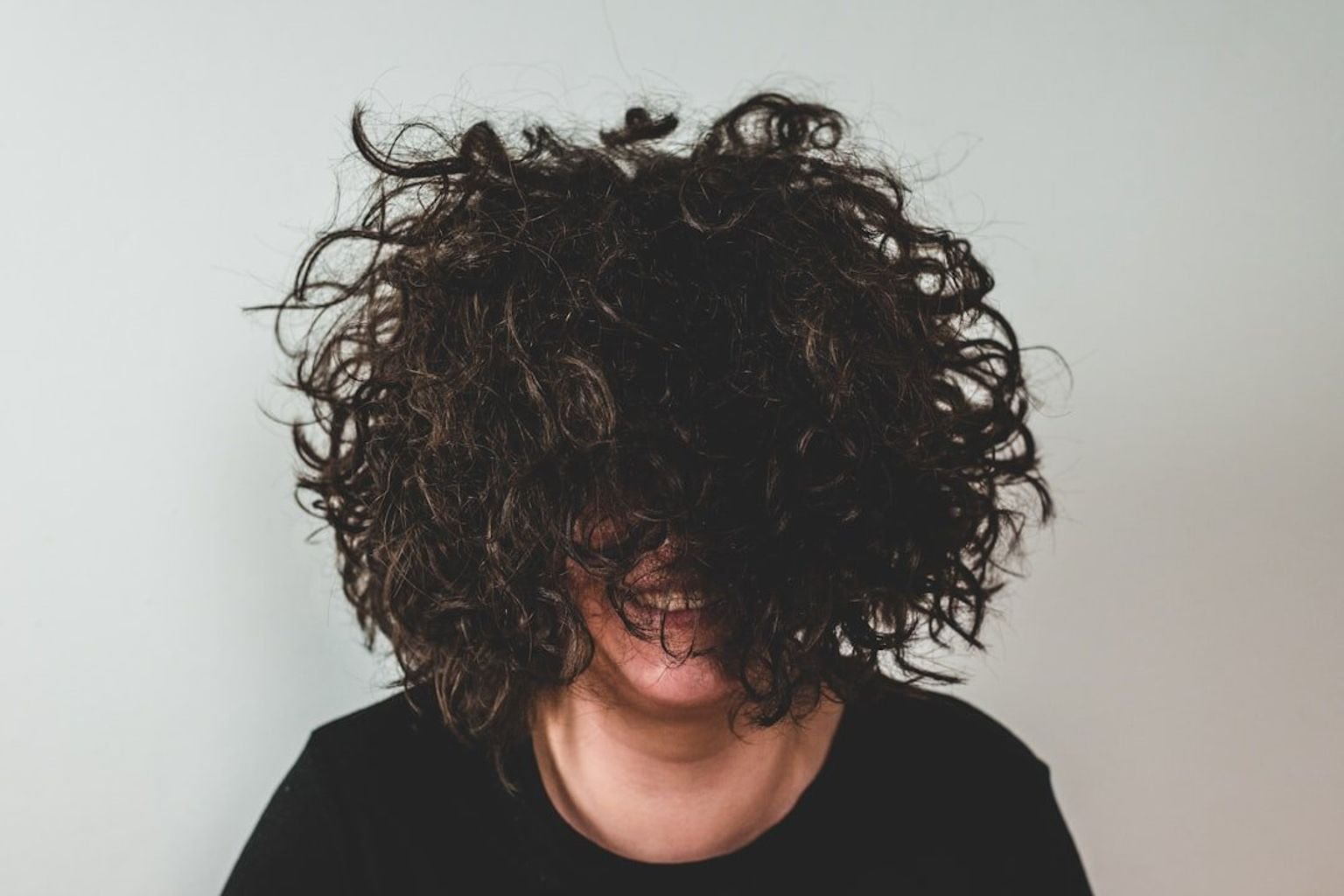 Curly shag haircut with layered crown volume and a balanced rounded silhouette