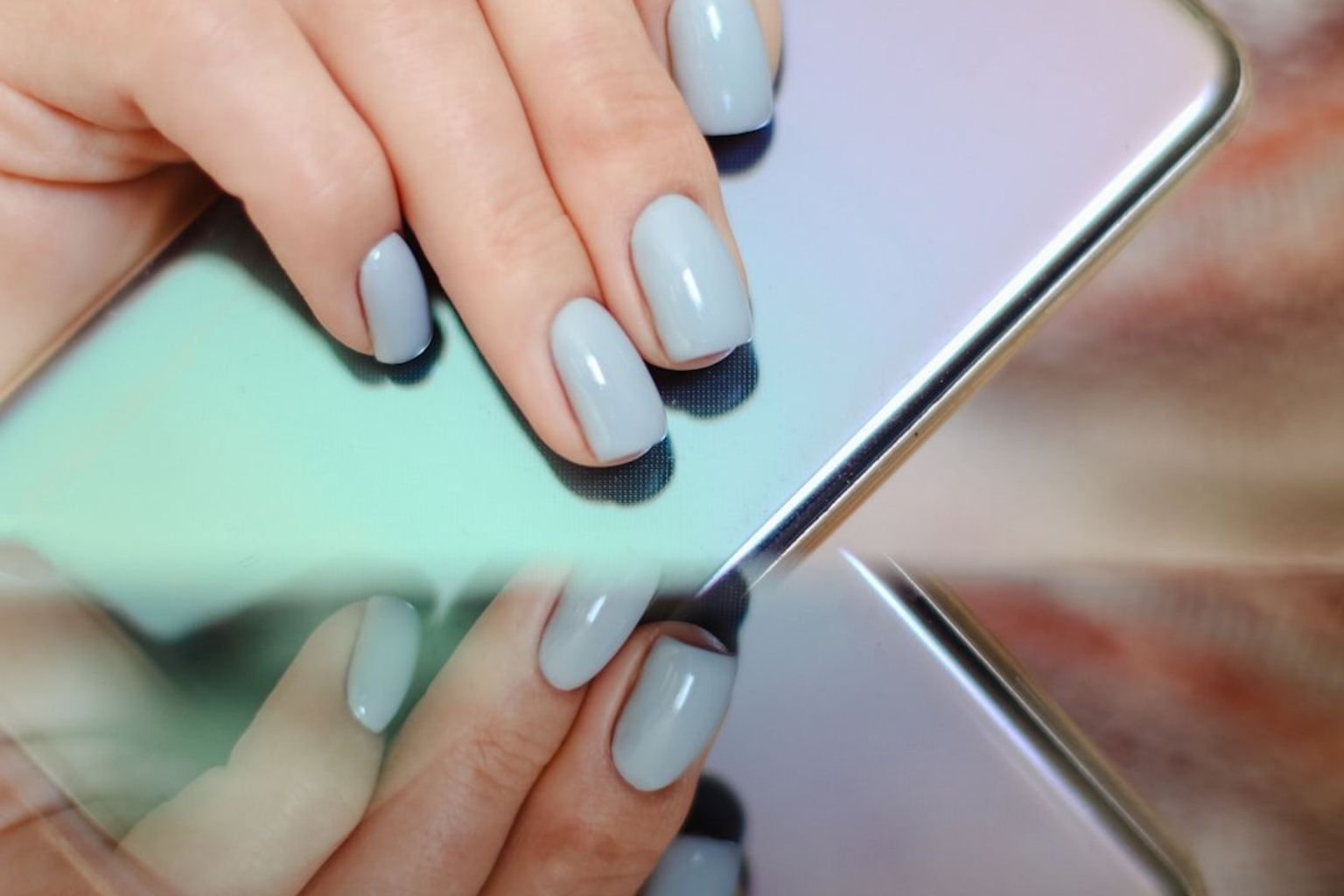 Denim-blue manicure with a reflective chrome metallic finish