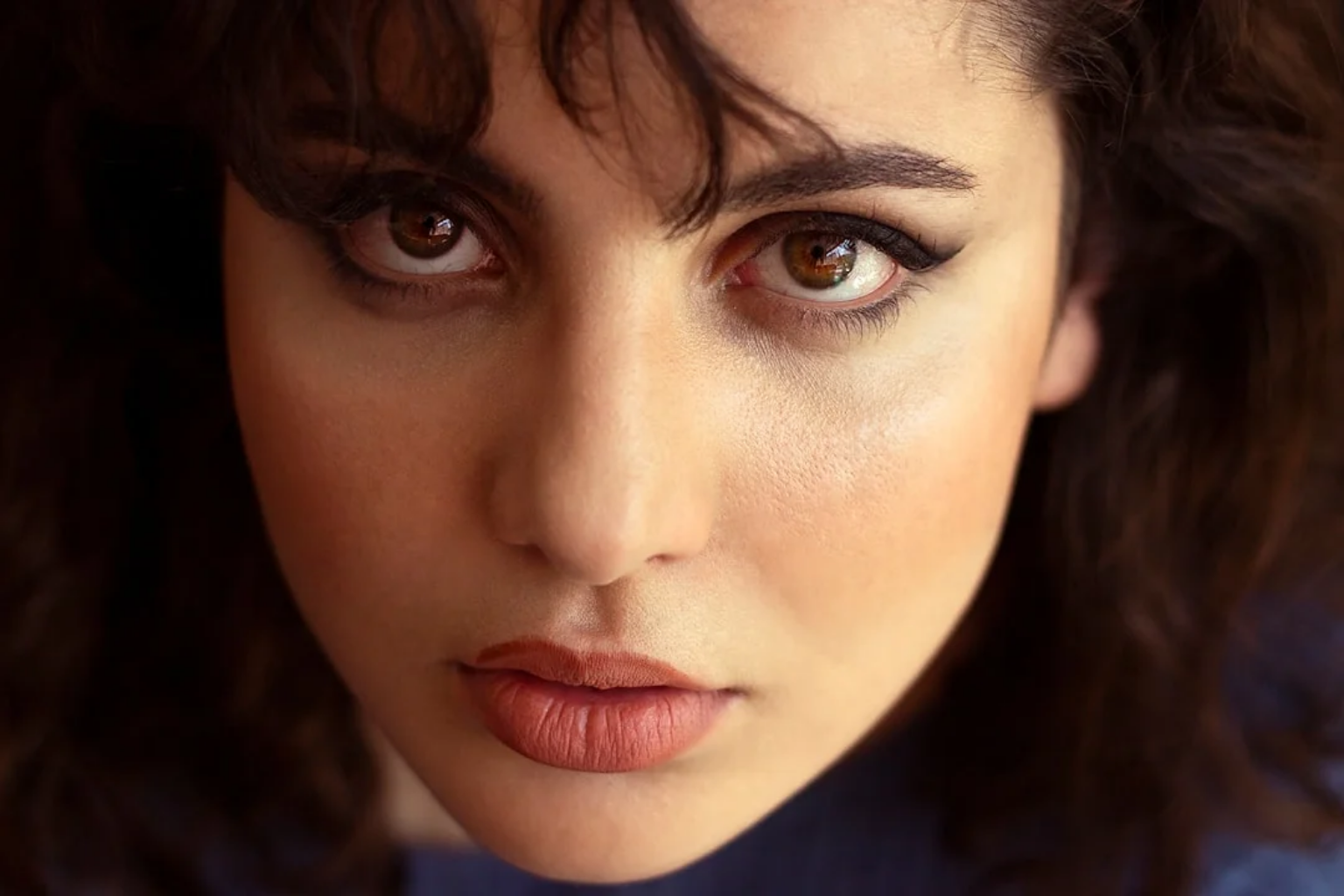 Close-up portrait with softly defined espresso-brown eyeliner and neutral eye makeup