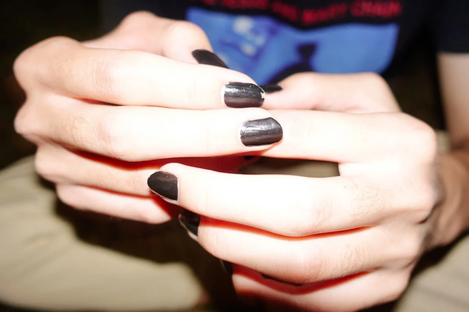 Hands with deep dark nails in a soft matte manicure finish