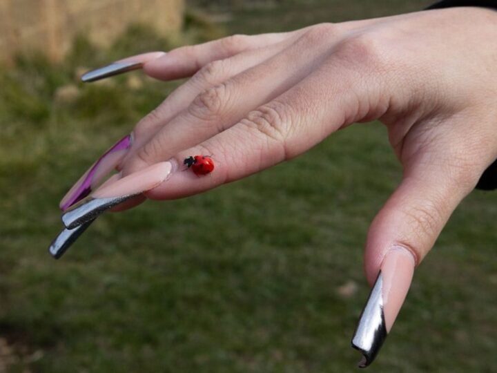 Close-up manicure with reflective silver metallic details and a liquid-metal finish