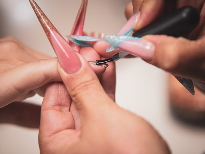 Manicurist painting nails during a salon service