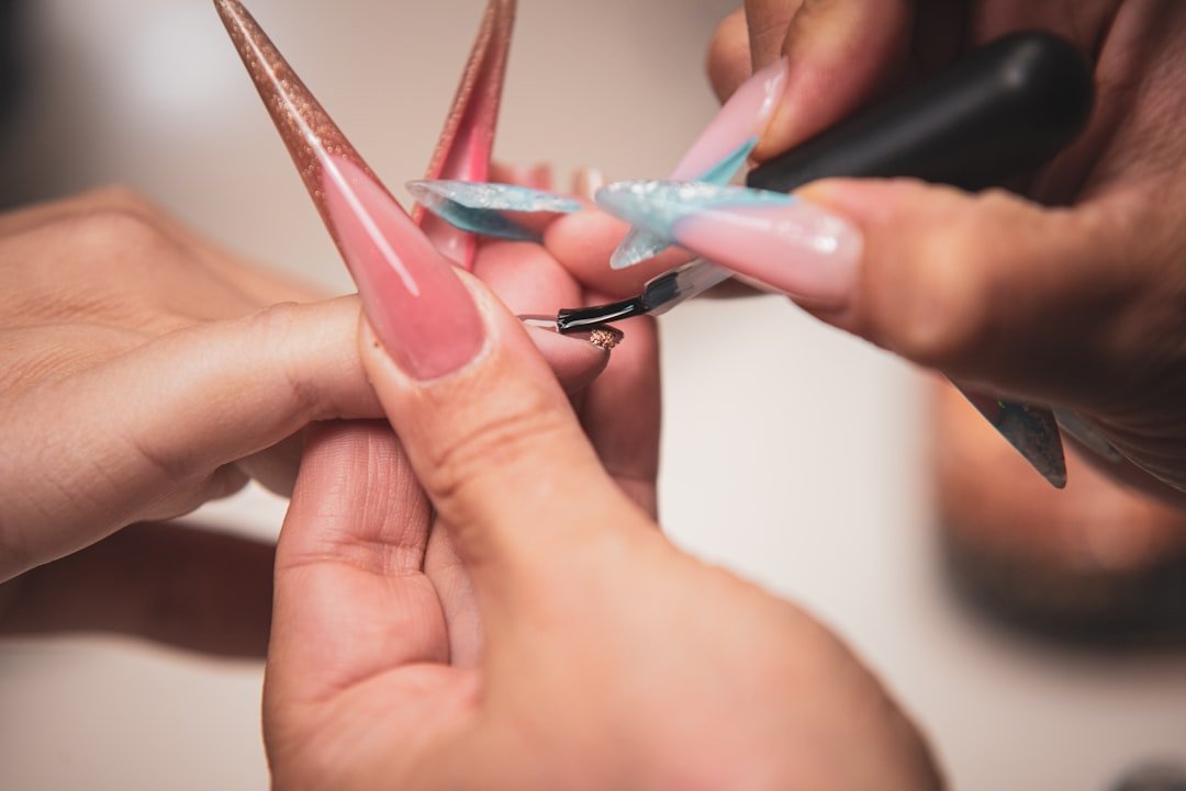 Manicurist painting nails during a salon service