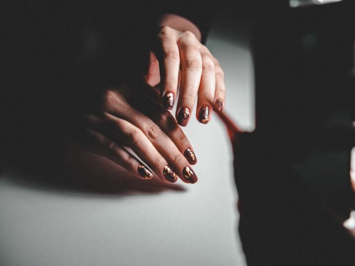 Manicured hands resting on piano keys