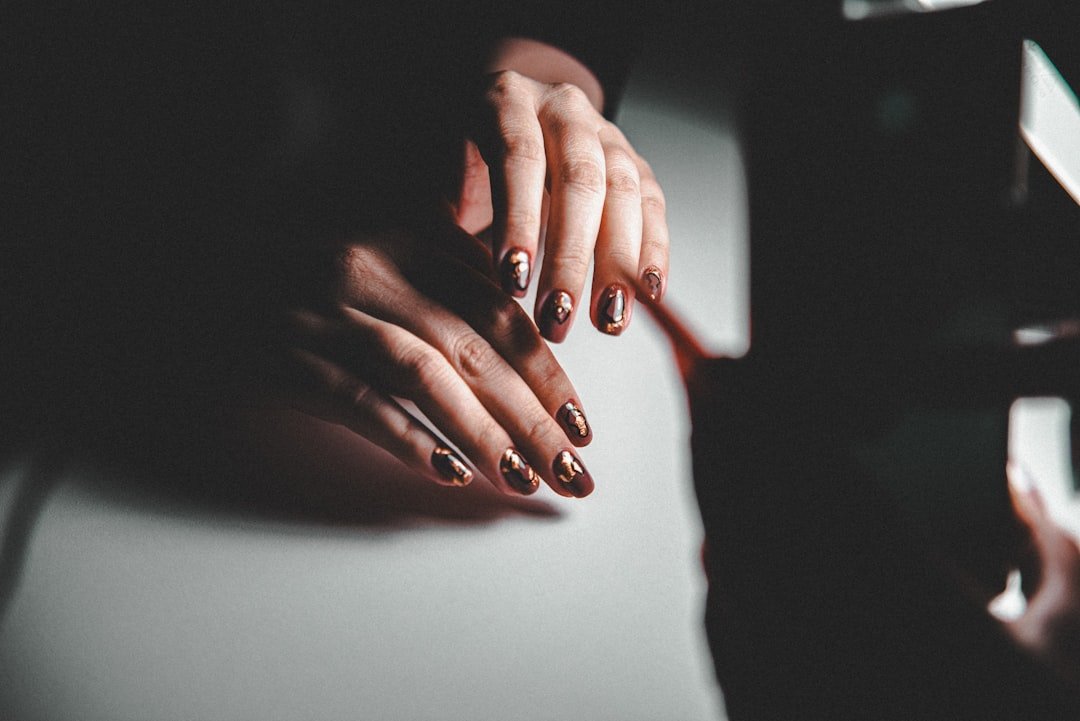Manicured hands resting on piano keys