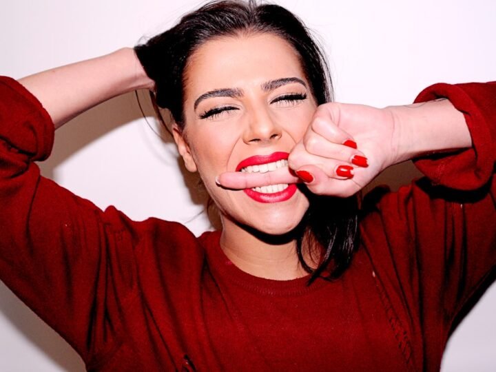 Woman wearing red lipstick with coordinated red beauty styling