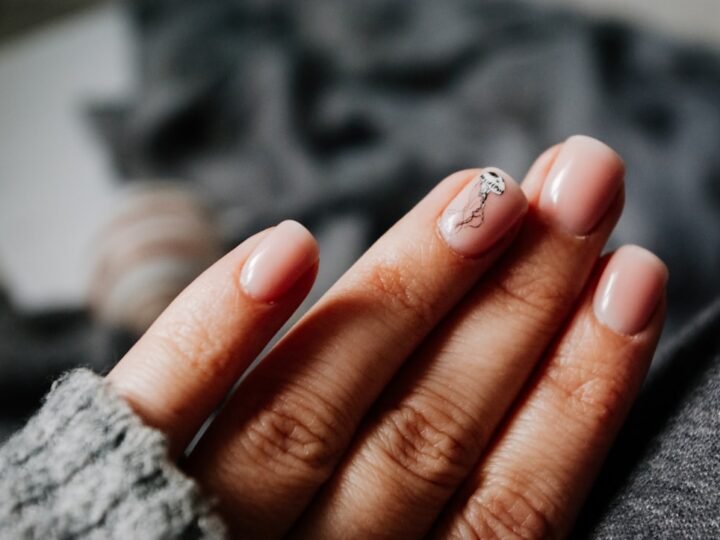 Manicured fingers with a silver ring and clean nail finish