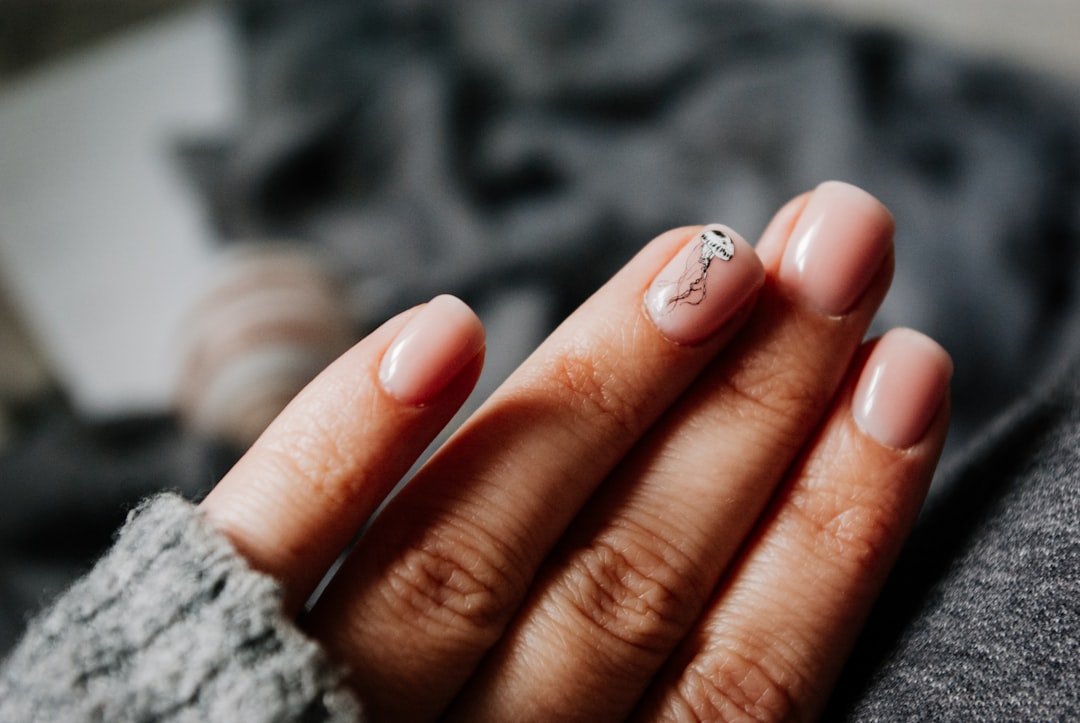 Manicured fingers with a silver ring and clean nail finish