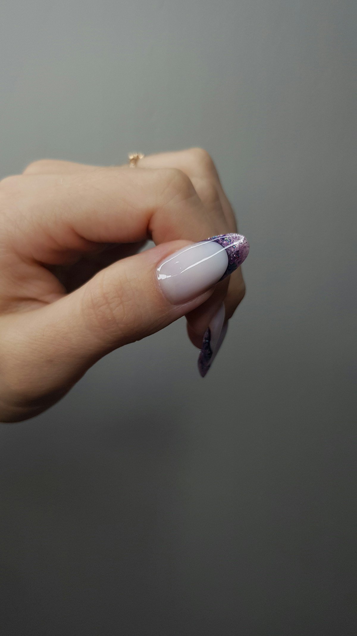 Hand with a French manicure and a restrained glitter accent