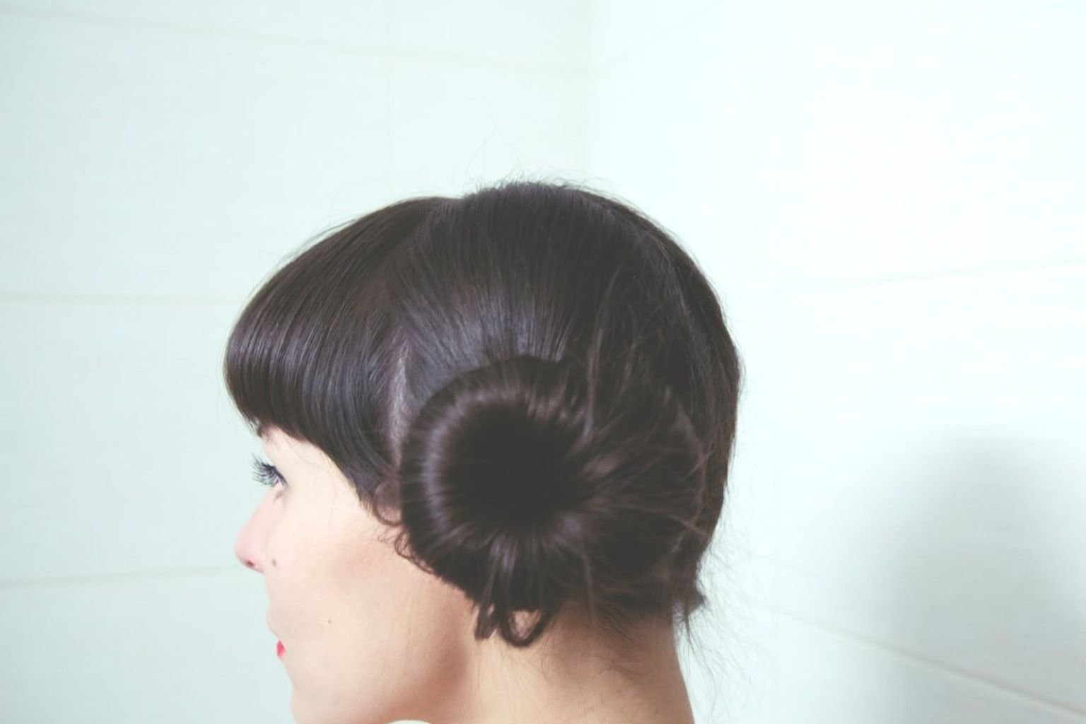 Soft low chignon with a loose polished finish and gentle movement around the head