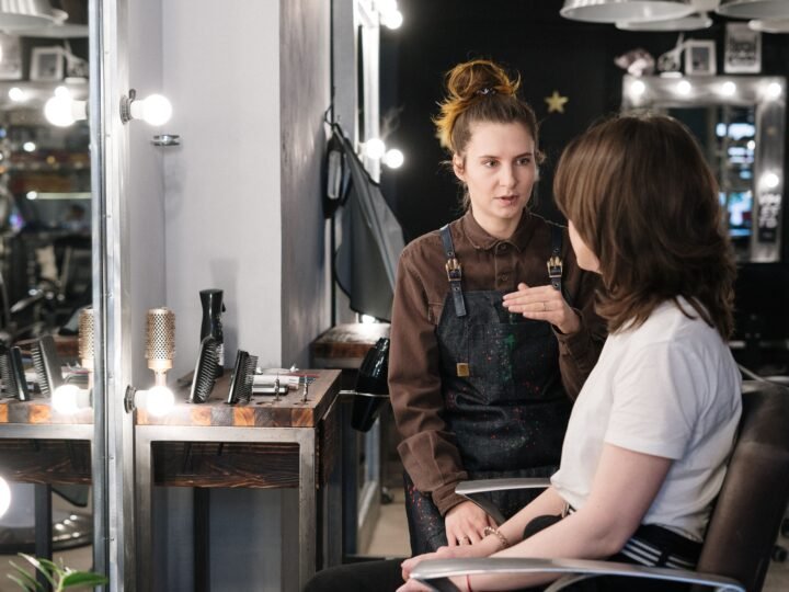 Stylist and client discussing a haircut during a salon consultation